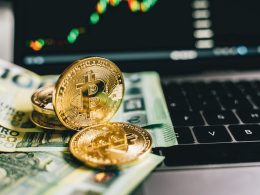 Bitcoin and some US dollars on laptop keyboard with a background of laptop screen with bitcoin price chart