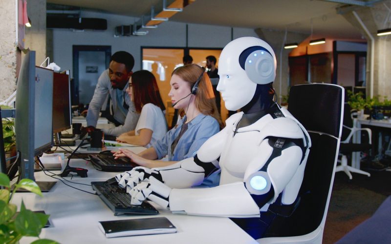 Robot working on a computer in office