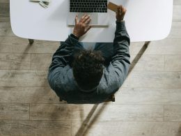 Person using a laptop and credit card, symbolizing online financial freedom